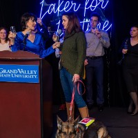 Group of people on stage with service dog